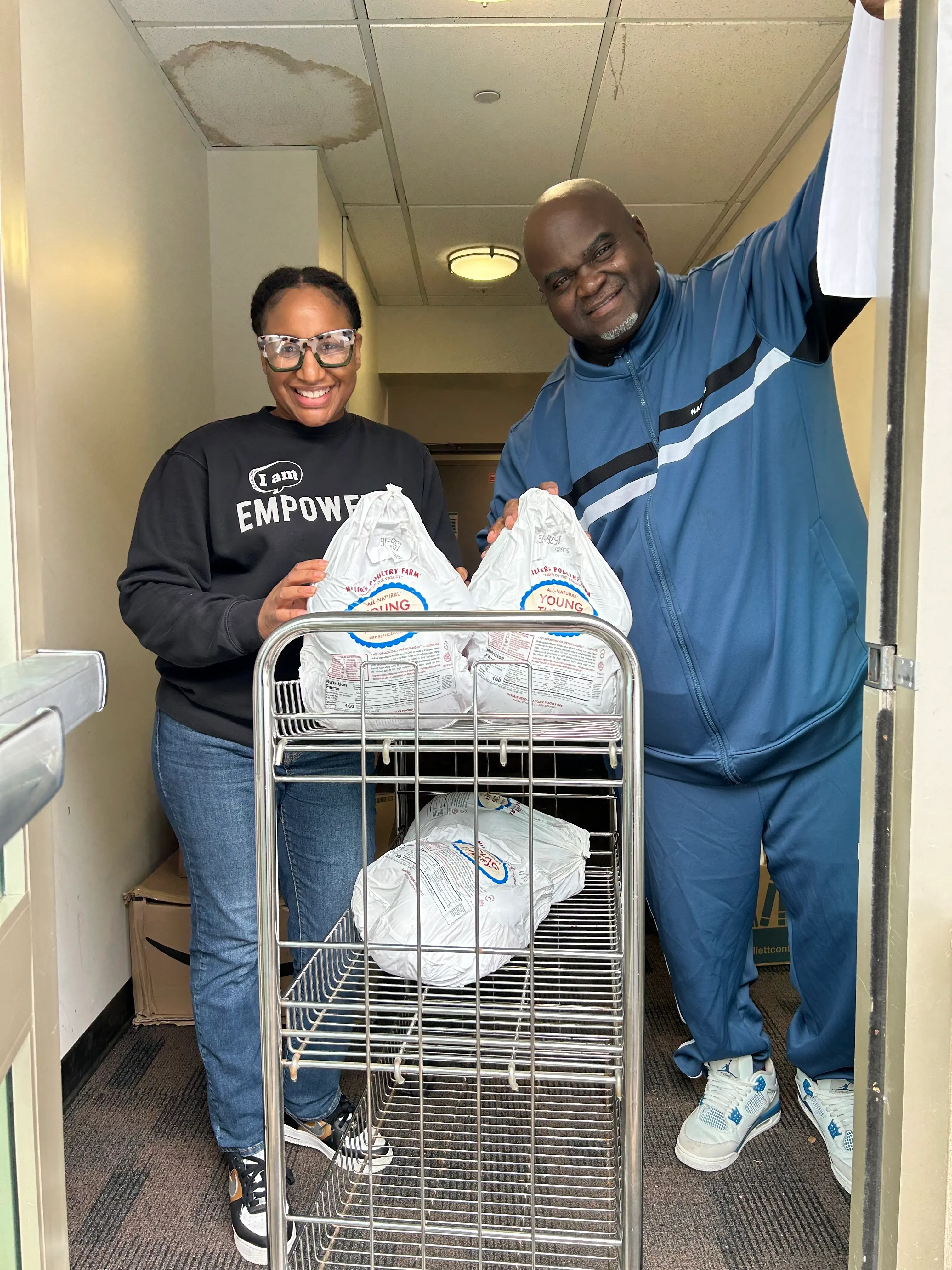 Volunteers with a cart of turkeys ready for Thanksgiving distribution